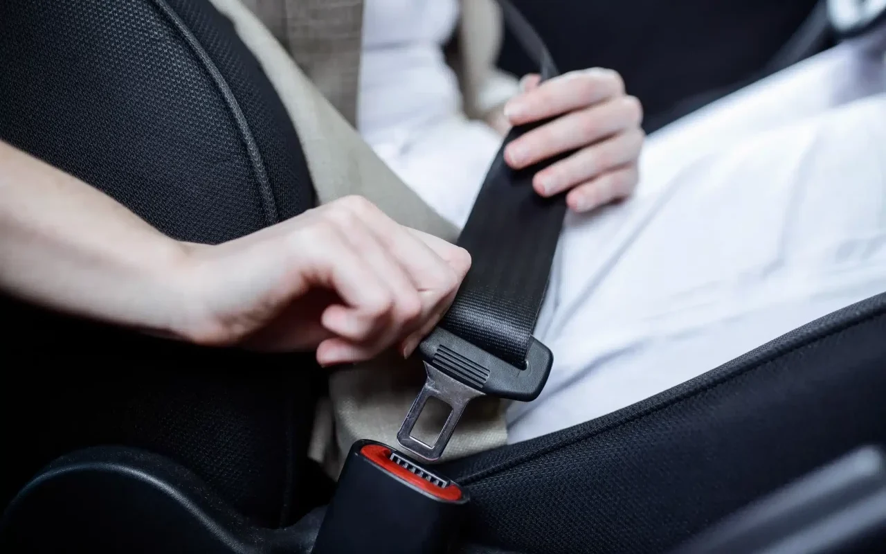 vista aproximada de mulher a colocar o cinto de segurança