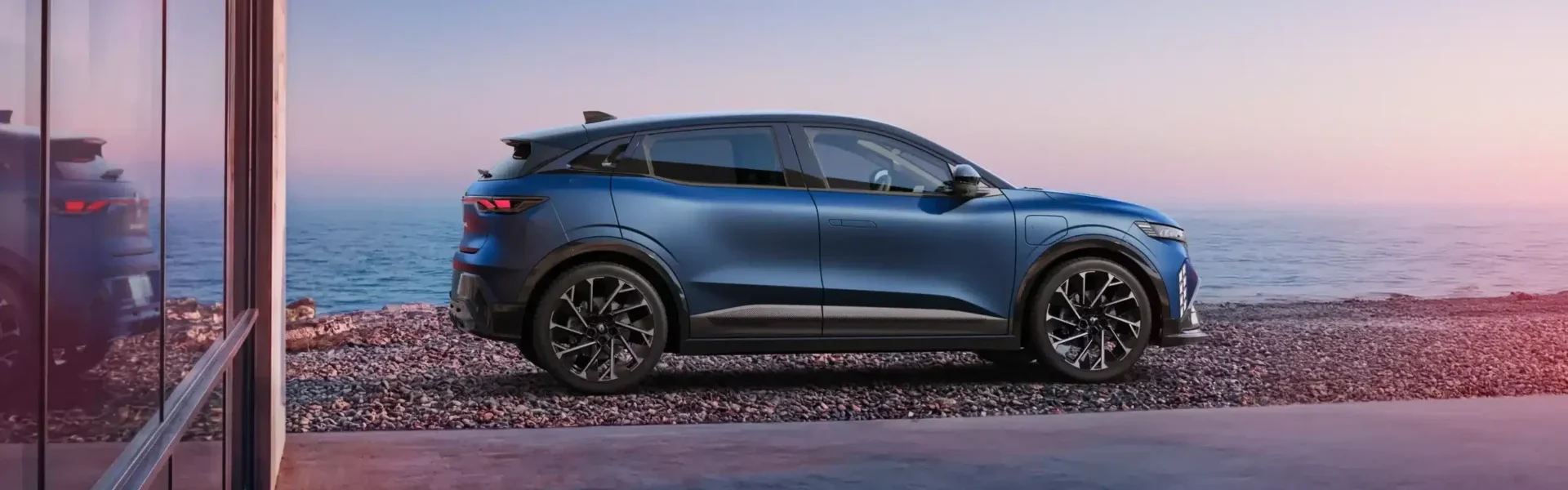 Vista lateral do Renault Megane E-Tech elétrico em azul com jantes em liga leve diamantadas
