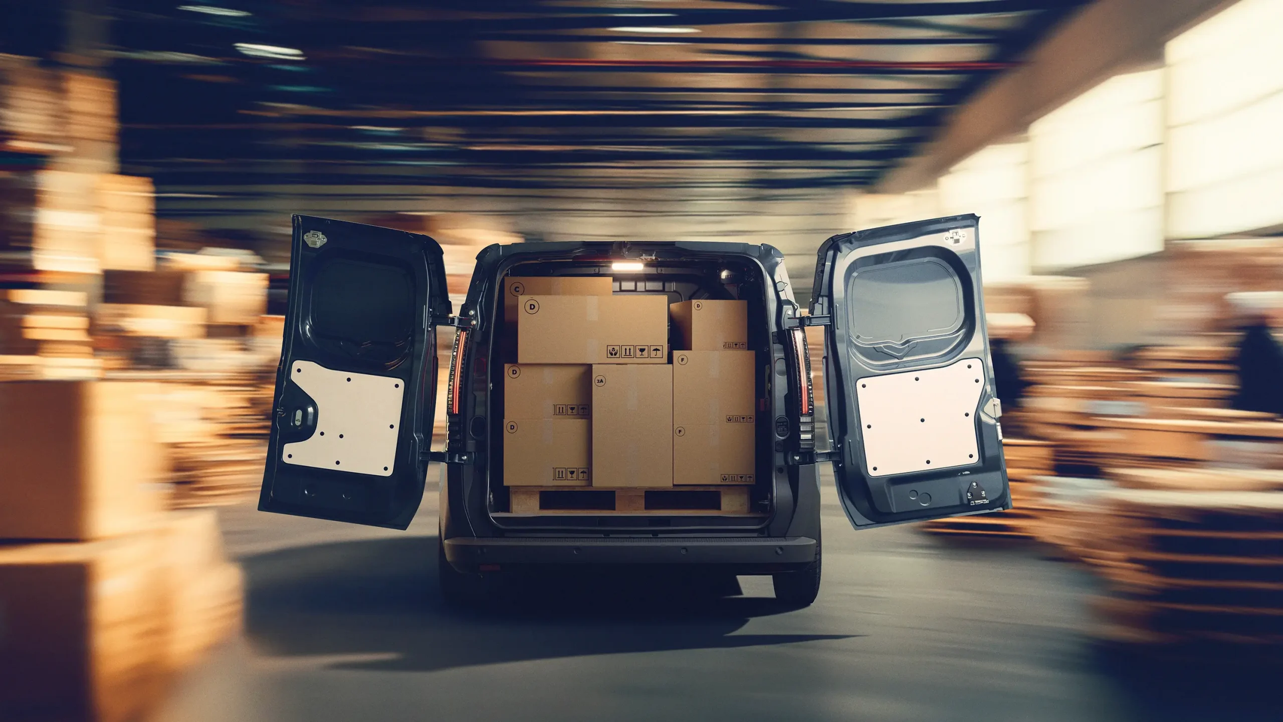 Renault Traffic Van E-Tech visto com as portas de trás abertas e caixas dentro da mesma