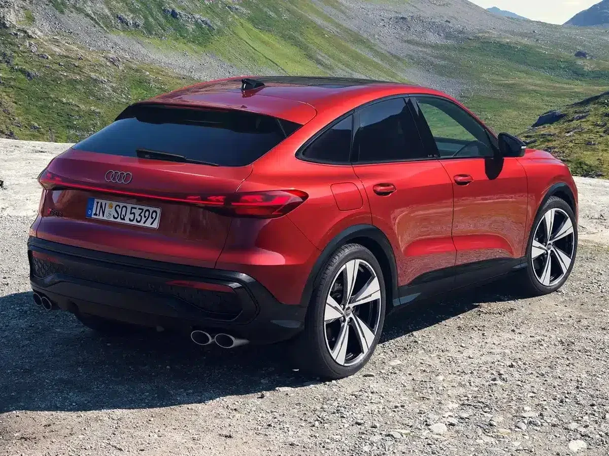Audi SQ5 Sportback vermelho visto de traseira numa paisagem montanhosa