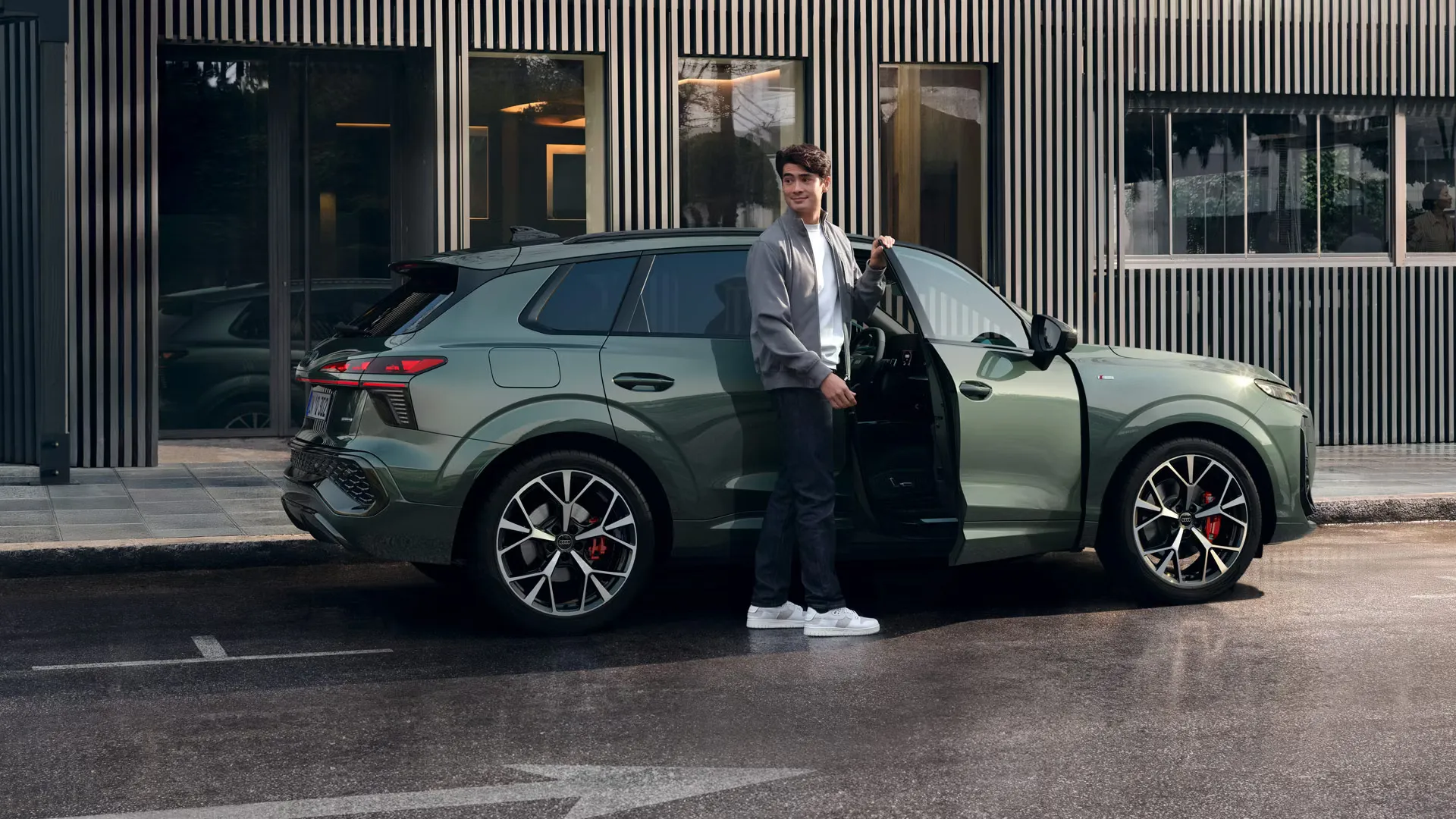 Jovem a entrar no novo Audi Q3 e-Hybrid na cor verde salva