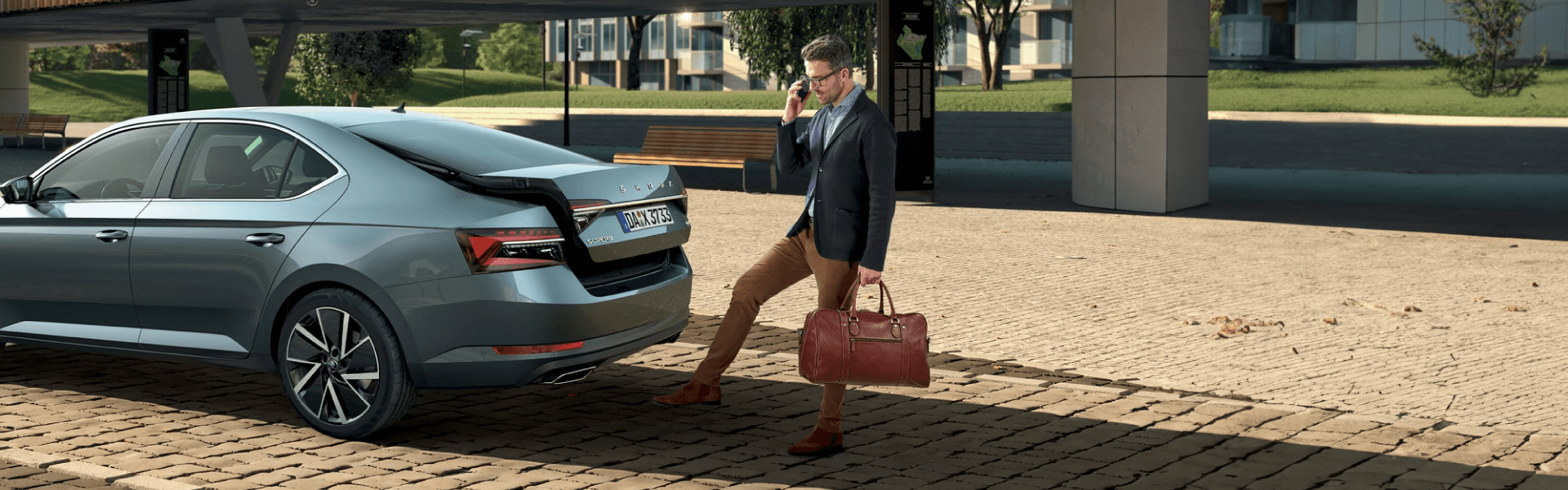 executivo a abrir a mala do seu carro de empresa Škoda