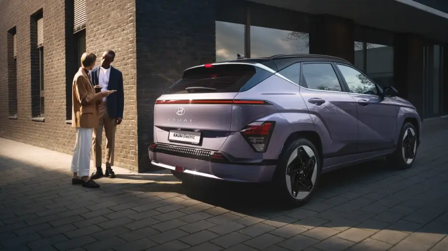 Hyundai KAUAI Elétrico visto de traseira com pessoas a conversar atrás dele