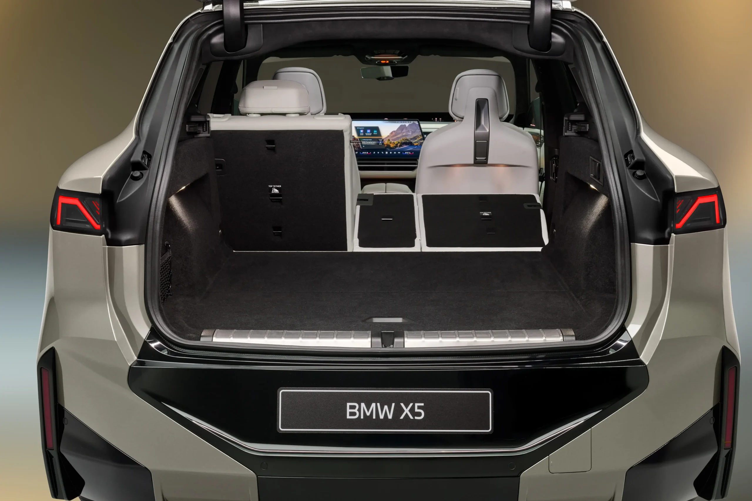 Vista traseira da bagageira do BMW X5 aberta com um dos bancos traseiros rebatidos