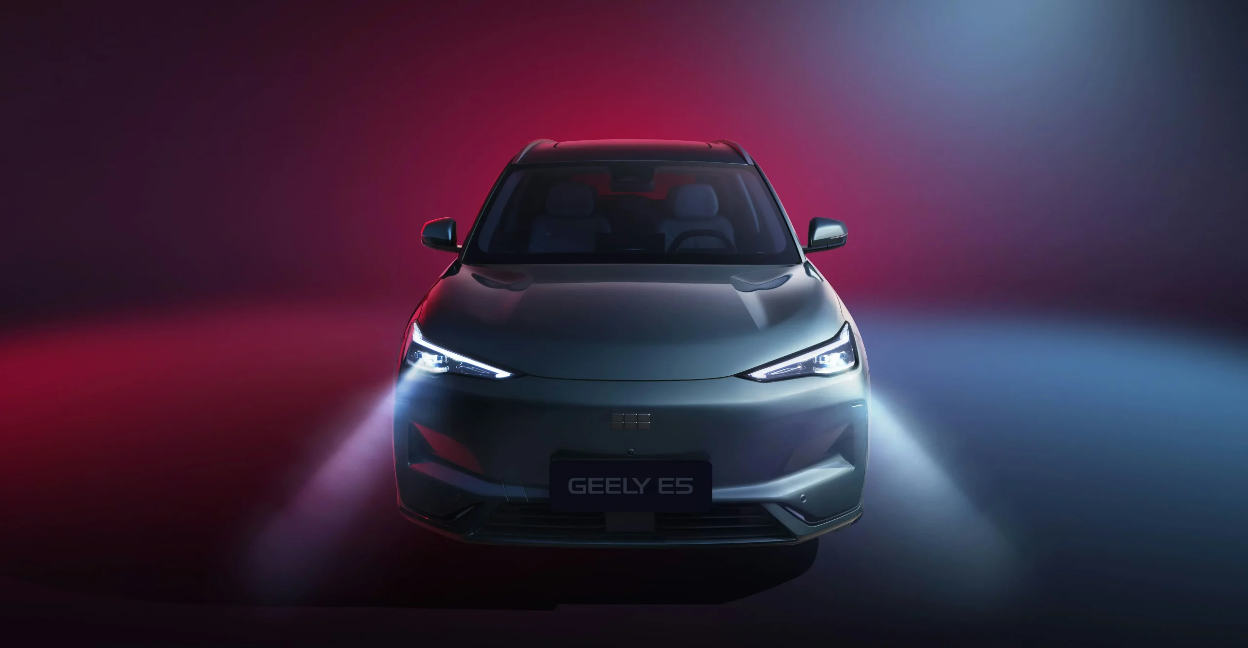 Vista frontal do Geely E5 com luzes ligadas