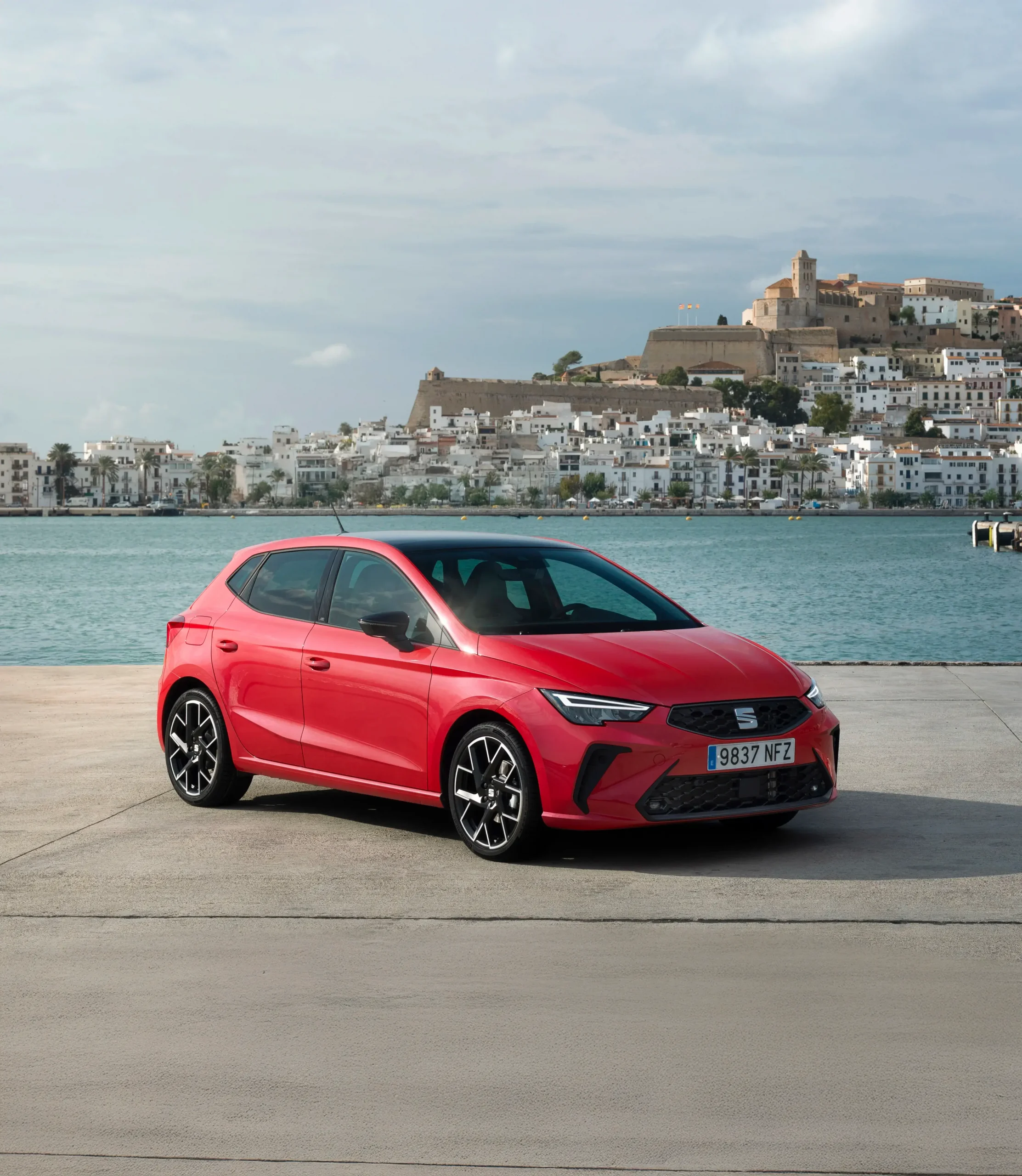 SEAT Ibiza vermelho com paisagem de mar atrás