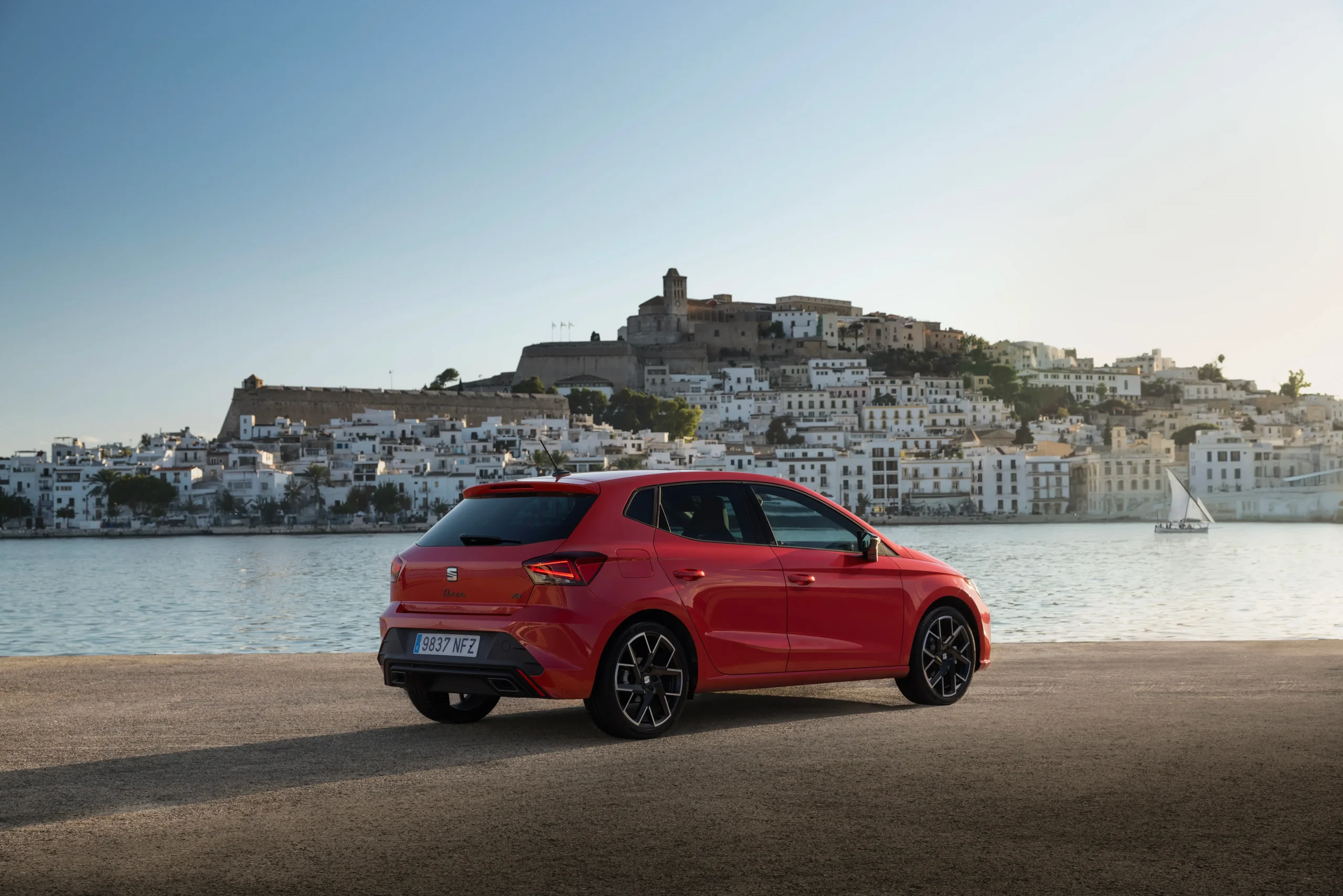 SEAT Ibiza vermelho de traseira com paisagem de mar atrás