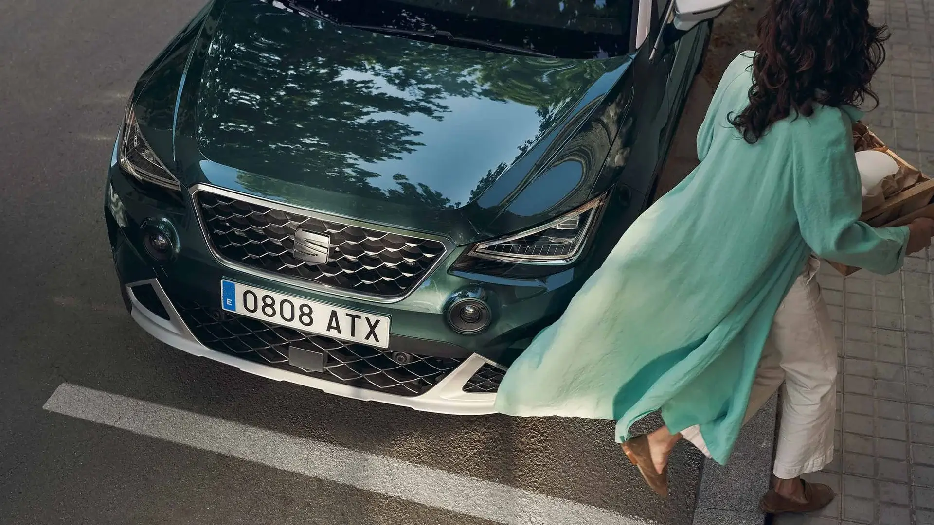 Vista aproximada de carro SEAT com mulher a passar ao lado